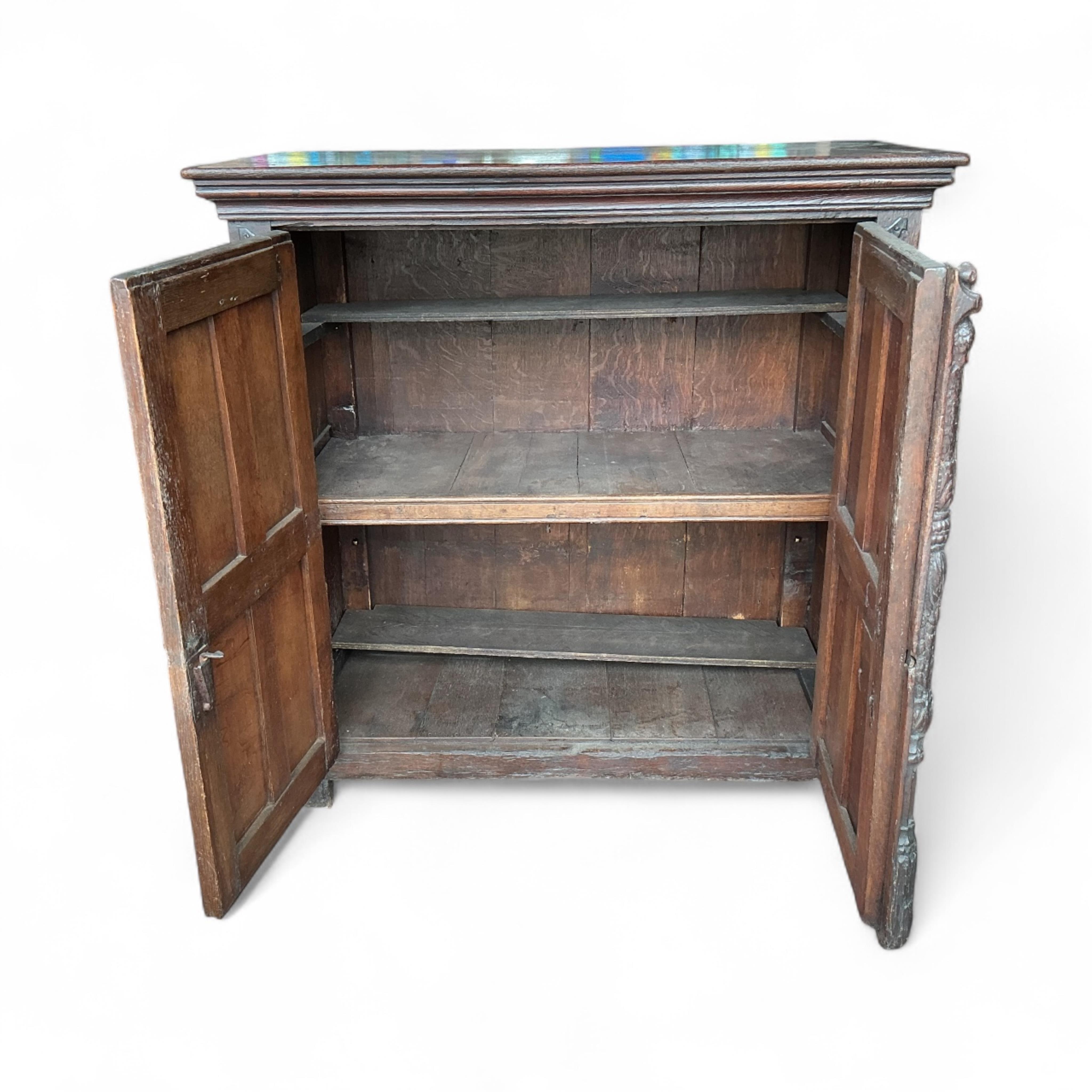 An 18th century and later French carved oak two door cabinet, width 115cm, depth 53cm, height 115cm